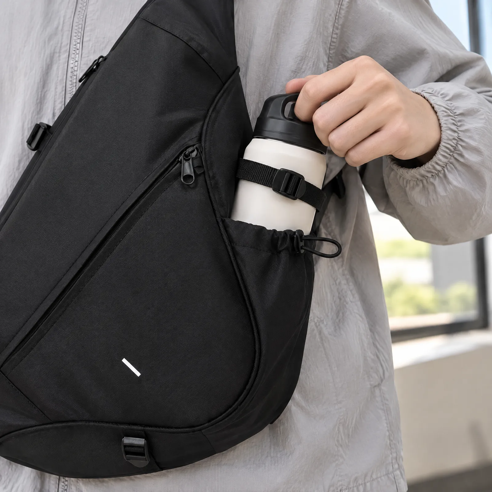 Rhys Sling Bag with a bottle in the side sleeve; bottle not included